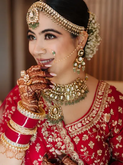 A close-up portrait of a bride, her smile radiant, showcasing her beautiful makeup and jewelry.