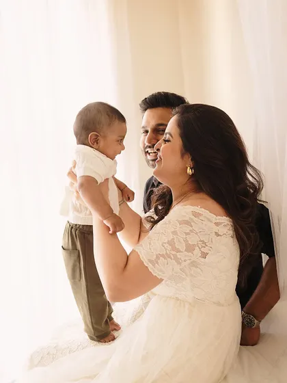 A family's joy. This candid shot captures the natural interaction and happiness of new parents with their baby.