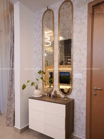 A sleek and modern foyer unit with two tall, oblong mirrors that create an illusion of height. The white and dark wood console provides stylish, concealed storage.