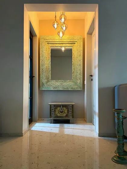 Every corner tells a story. This entryway nook uses an intricately carved mirror and a small chest to establish the home's unique Bohemian character from the moment you step inside.