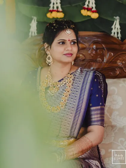 A candid portrait of the bride looking away, framed by a soft foreground, creating a dreamy and thoughtful mood.