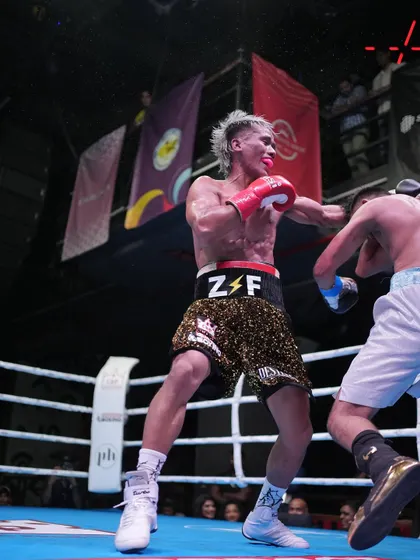 A dynamic action shot of Zoramchanna landing a punch, demonstrating his speed and agility in a live fight.