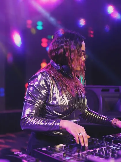 A side profile of me at the console, with colorful disco lights creating a classic party atmosphere.