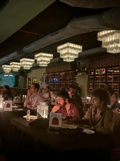 A candid moment from our ZNMD night in Mumbai. The focus is on the screen, but the tables are set for a culinary journey, with wine and the first course ready, showing how we seamlessly blend dining with viewing.