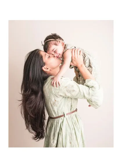 A mother and daughter share a kiss in this lovely lifestyle portrait.