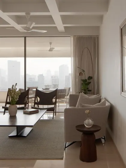 A serene living space in our Altamount Road apartment project in Mumbai. The design uses a neutral palette and clean lines to create a calm retreat from the city, with large windows framing the urban skyline.