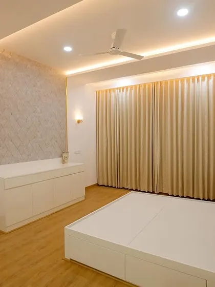 This all-white bedroom is the epitome of serenity. Gold accents on the wall paneling and light fixtures add a touch of glamour, while the full-length curtains create a soft, dreamy ambiance.