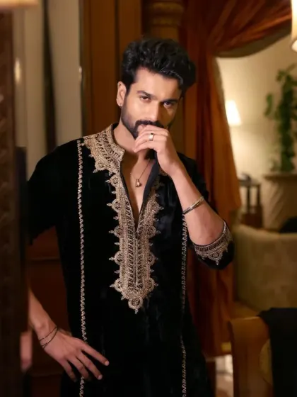 A black velvet kurta with rich copper-gold embroidery around the neckline. The velvet fabric makes it a luxurious choice for winter festivities.