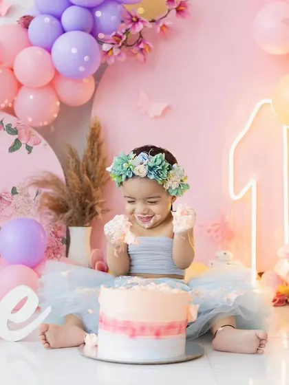 A spoonful of cake and a whole lot of happiness. This close-up shot captures the pure delight of a first birthday cake smash.