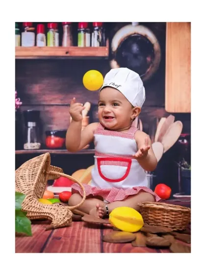 Here is a shot from my popular 'Little Chef' theme. This little one is having a blast playing with props in a miniature kitchen setup, creating such a playful and dynamic portrait.
