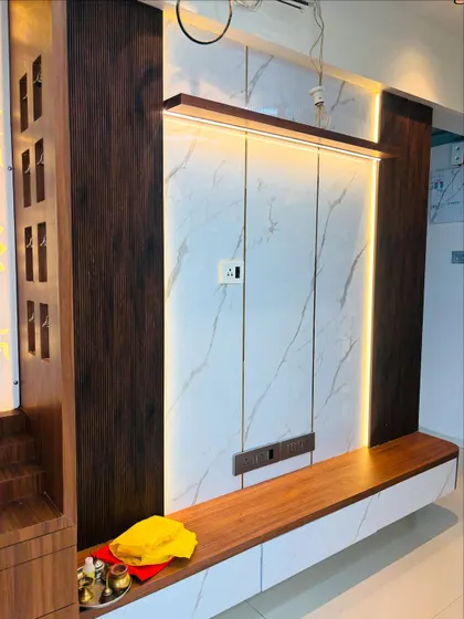 Another angle of the marble and wood TV unit, showing the clean lines and the warm ambient light it adds to the room.