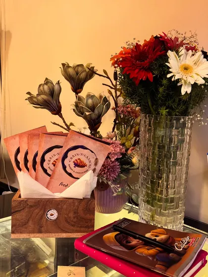 Chocolate pieces sit beside flowers and our branded takeaway bags at the Jayanagar counter.