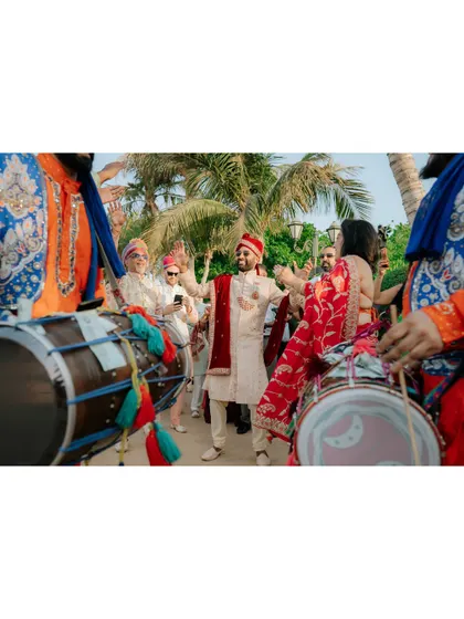 Capturing the energy of the groom's arrival with dhol players, a key part of a vibrant Indian wedding.