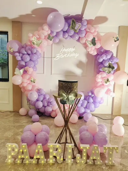 I love the butterfly theme for its elegance. Here, I built a full circular balloon arch in pink and lavender, with a custom "Happy Birthday" neon sign inside and light-up marquee letters for the name, creating a beautiful photo corner.