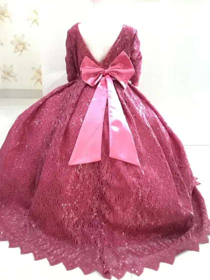 The back of this deep pink gown features a large satin bow and a scalloped hemline.