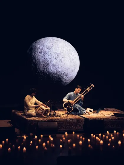 A moment of connection during a 'Sitar for Mental Health' performance in Bangalore. My shows are designed as immersive experiences, using visuals like this moon projection and candlelit stages to create a serene, meditative atmosphere perfect for wellness events and intimate gatherings.