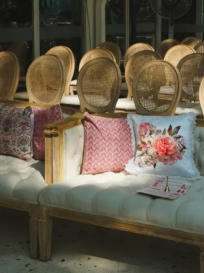 Comfortable and stylish seating for the family during the wedding ceremony. The floral cushions add a pop of color and softness to the rustic wooden bench.