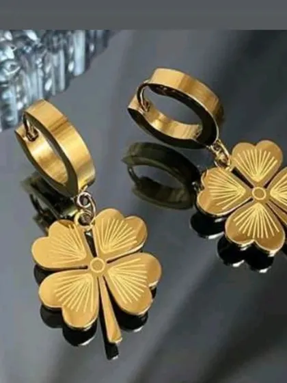 A pair of dangling hoop earrings with etched four-leaf clover charms. This is a beautiful and unique design for those who love this lucky symbol.