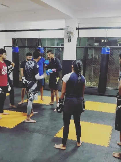 Instructing a student during a kickboxing drill. Personal attention is key to making sure everyone understands the fundamentals and stays safe.