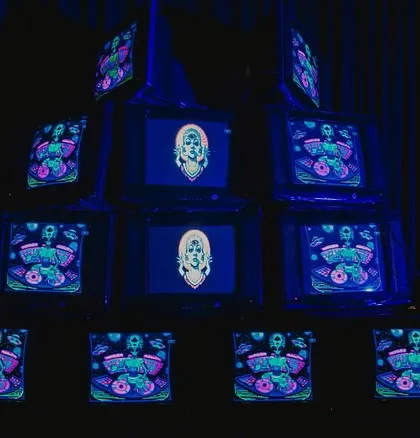 An installation of stacked vintage television sets displaying psychedelic, custom-made visuals. This retro-tech art piece was a major focal point and conversation starter.