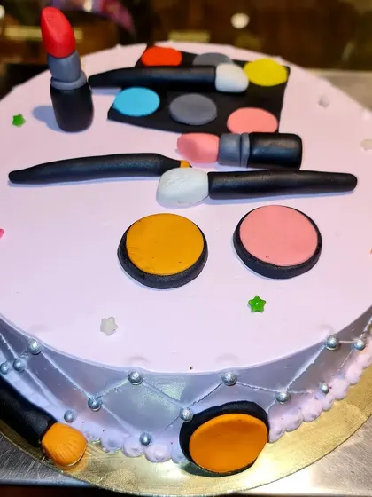 The perfect cake for a makeup enthusiast. This red velvet cheesecake is topped with a variety of edible, handcrafted makeup items, including lipstick, eyeshadow palettes, and brushes.