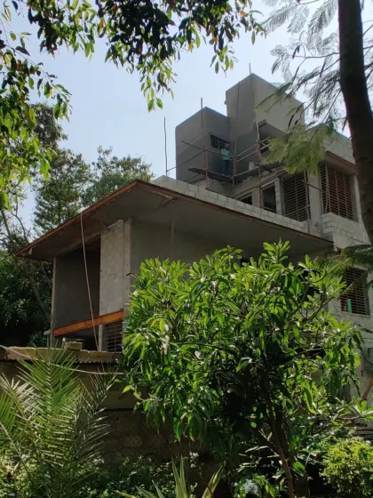 The bare shell of Villa 14, framed by lush green trees.