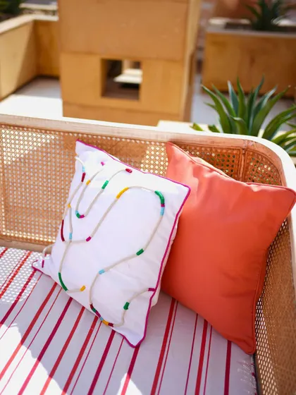 A colorful embroidered cushion, adding another layer of texture and fun to the lounge seating.