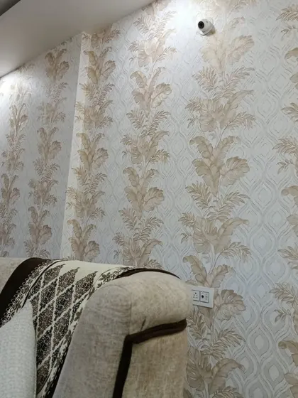 This living room features a subtle wallpaper with a vertical leaf pattern in neutral tones, creating a calm and elegant backdrop for the seating area.