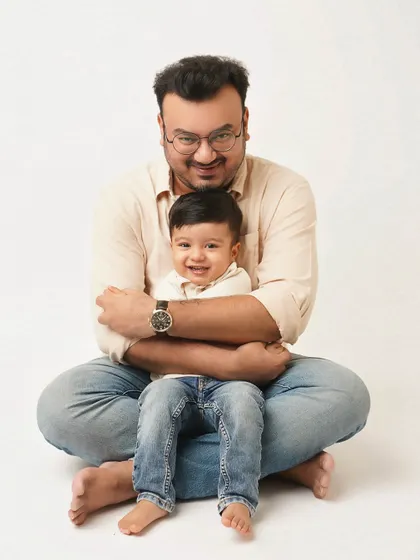 A father gives his son a gentle hug from behind. This pose is full of warmth and protection, a beautiful depiction of a father's love.