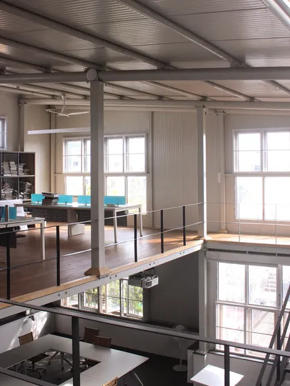 This wide shot showcases the multi-level, open-plan design of our studio. The mezzanine level creates distinct work zones while maintaining the open and collaborative atmosphere of the industrial-style space.