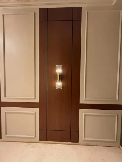 The full view of the entrance wall paneling, combining dark wood tones with classic off-white molding. This creates a timeless and elegant look.