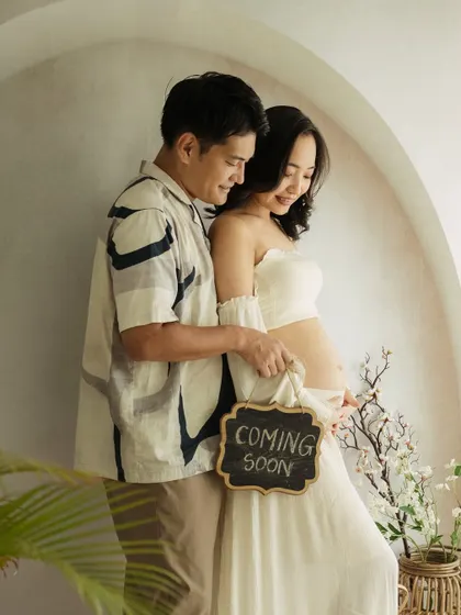 "Coming Soon." A classic announcement shot, made beautiful by the couple's gentle interaction and the soft, airy studio light.