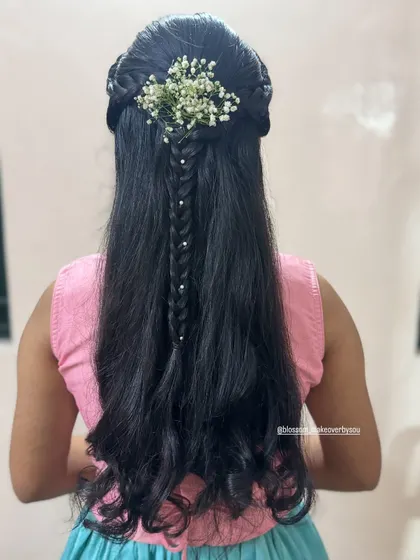 A direct back view of this braided hairstyle. The central fishtail braid is adorned with pearls, and the look is finished with fresh baby's breath for a soft, romantic feel.