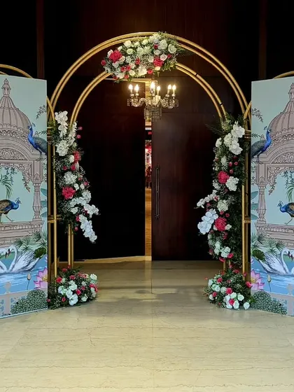 To bring a touch of traditional art to the entrance, I designed these custom panels with peacock motifs, framed by a modern gold arch and fresh flowers, blending heritage with contemporary style.