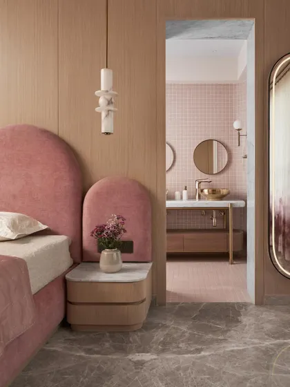 A glimpse from the kid's bedroom into the attached bathroom, showing how the design language and color palette connect the two spaces. The arched headboard echoes the arched doorways used elsewhere in the home.