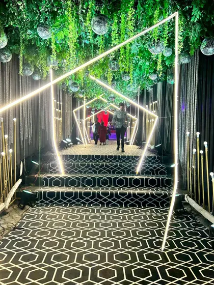 The full view of the Sangeet entrance tunnel, a perfect example of how we use lighting and structure to build excitement.