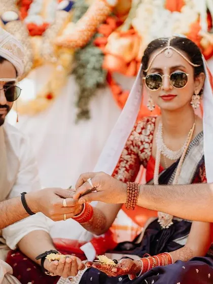 A modern couple, both wearing sunglasses, participating in their traditional wedding rituals.