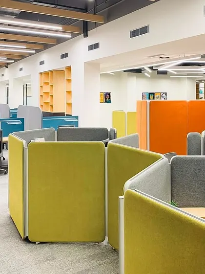 Flexible hexagonal pods by Featherlite used in the DLF hospitality office. This system allows for a dynamic and collaborative atmosphere, moving away from traditional cubicles to foster communication and teamwork.