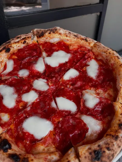 A close-up of our pepperoni pizza, with its perfectly charred crust and glistening pepperoni.