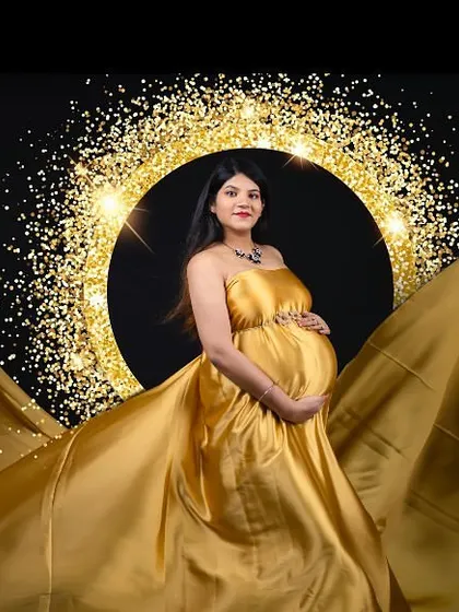 A golden goddess moment. This shot uses a flowing gold satin gown and a sparkling ring light to create a radiant and glamorous portrait against a black backdrop.