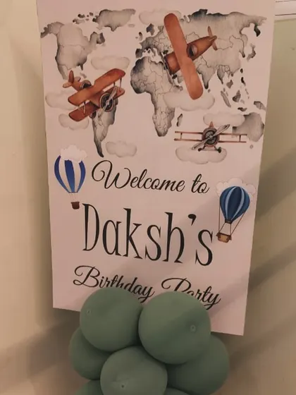 A welcome board for a travel-themed party with vintage airplane illustrations.
