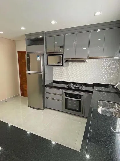 The tall unit in this kitchen neatly houses a refrigerator and a built-in microwave, demonstrating our expertise in creating custom solutions for appliance integration.