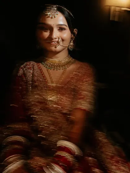 An artistic portrait of the bride using motion blur. The effect creates a dynamic and ethereal image, highlighting her smile amidst a swirl of color and light.