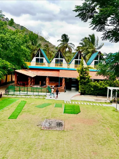The main building of our Nandi Hills resort, featuring our signature A-frame cabins. The large lawn is perfect for outdoor team activities and games.