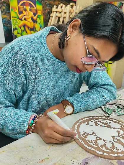 A student engaged in creating a detailed design on a ceramic plate. We provide all the necessary materials for you to explore this beautiful art form.