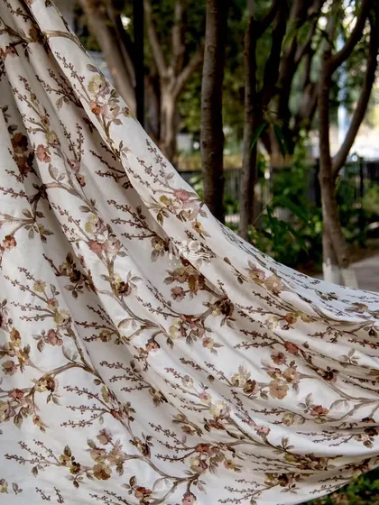 Our Ethereal Elegance fabric collection, featuring delicate floral prints on a soft neutral base, swaying in the breeze to embody a seamless harmony between nature and design.