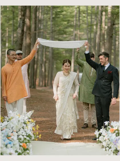 The bride's entrance, a beautiful tradition captured in a serene forest setting. The simplicity of the moment is what makes it so powerful.