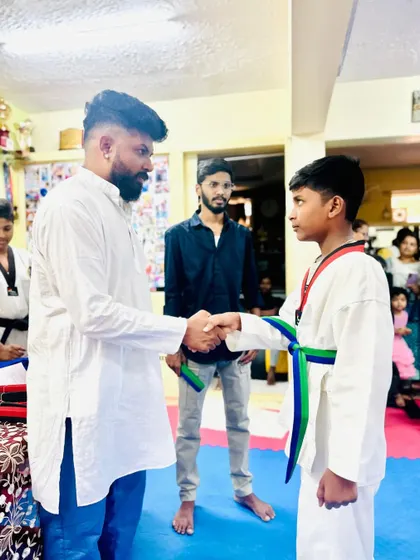 A handshake of congratulations for a newly promoted student.