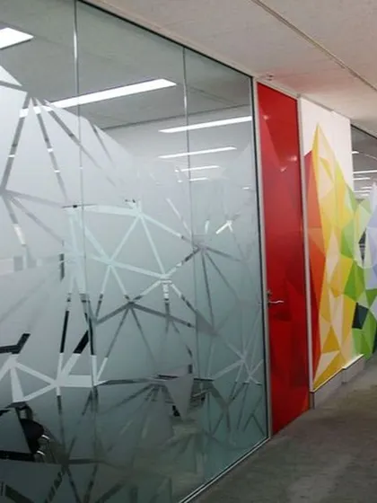 A closer look at the large-scale geometric frosted film, demonstrating how it breaks up the space and adds a layer of modern design to the office corridor.