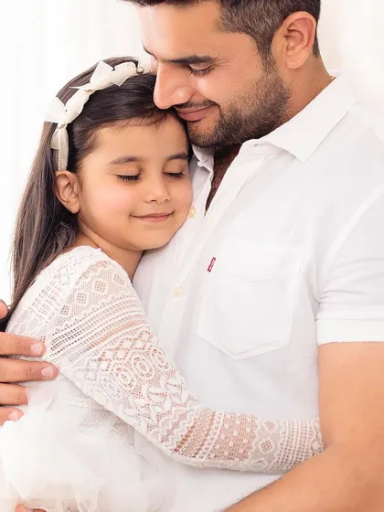 A father shares a quiet, loving hug with his daughter. These are the simple, powerful moments that tell the story of your family's love.
